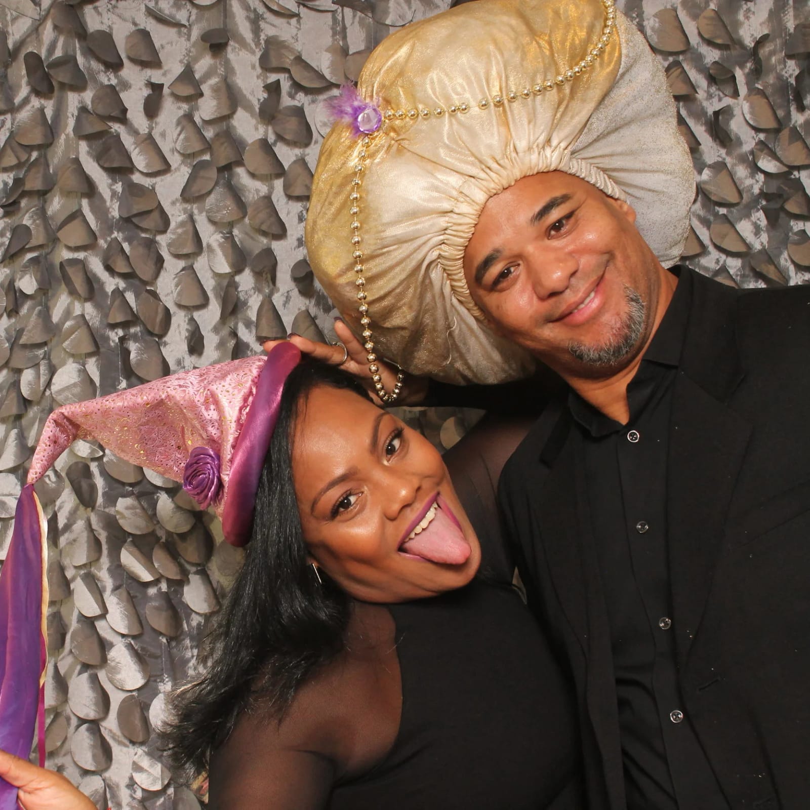 A pair of guests in playful costume hats striking a pose