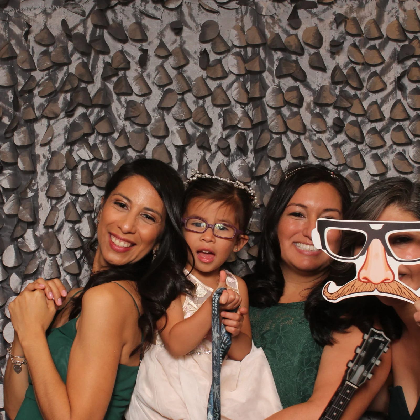 A family posing with silly glasses props in the photo booth