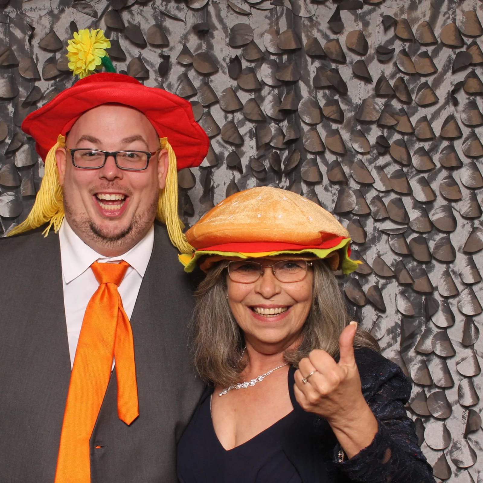 Two guests wearing fun food-shaped hats in the photo booth