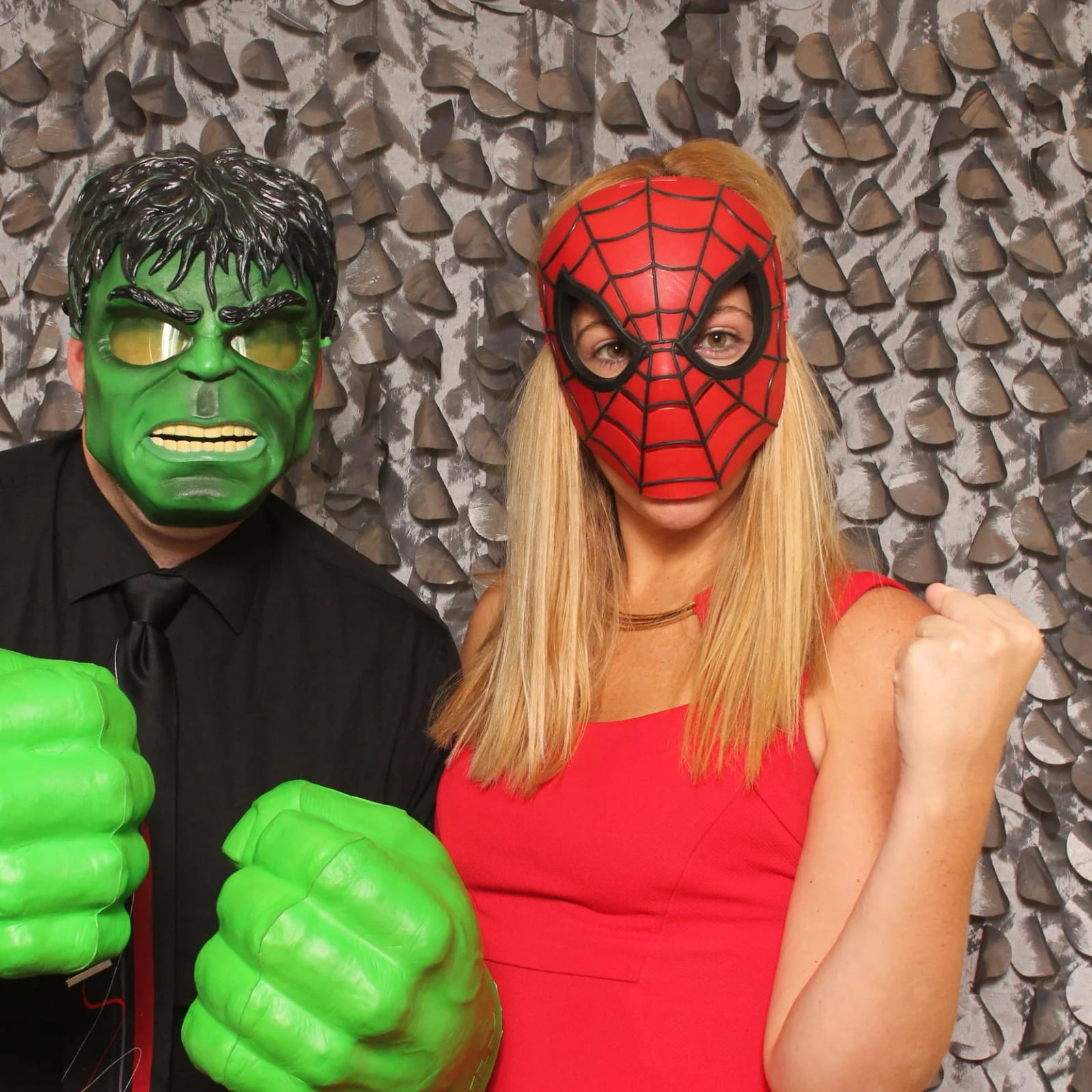 Two guests wearing superhero masks and foam fists for the camera